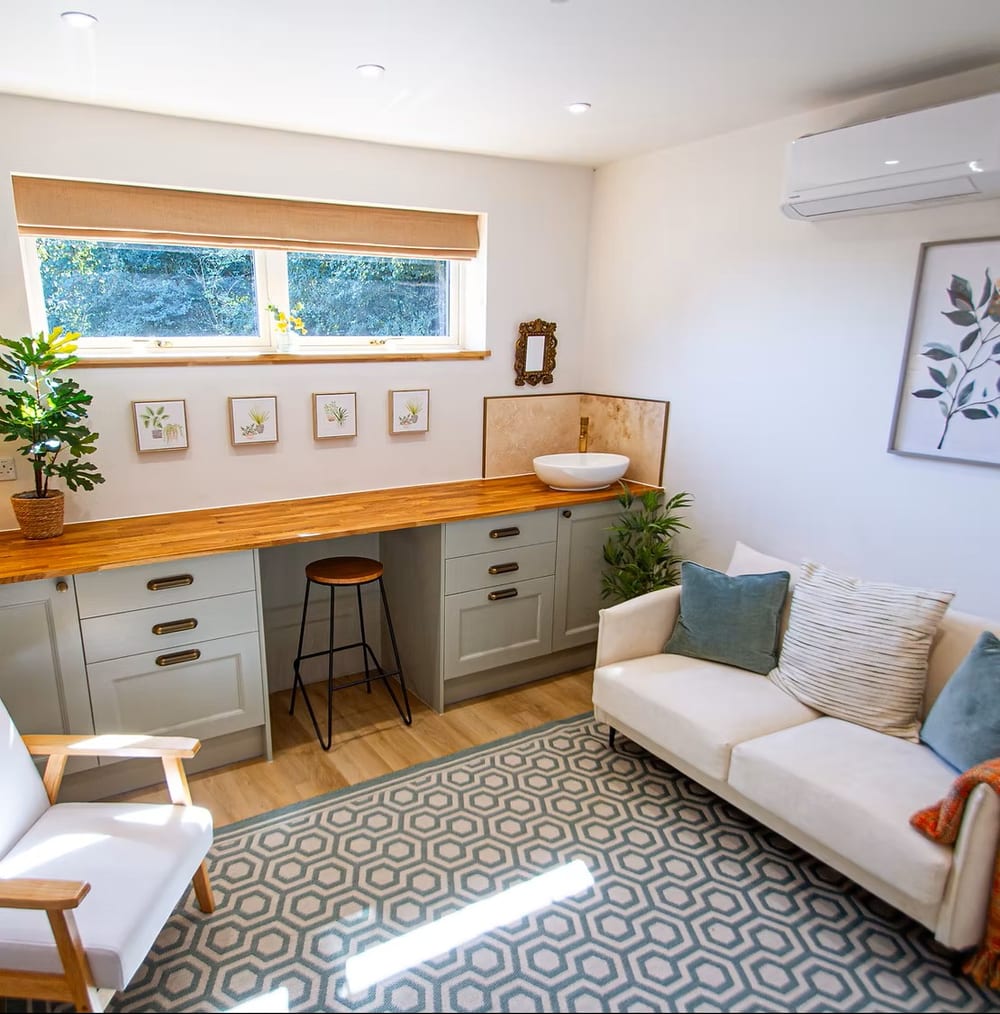 A calm, bright therapy room with a comfortable sofa, armchair and soft natural light